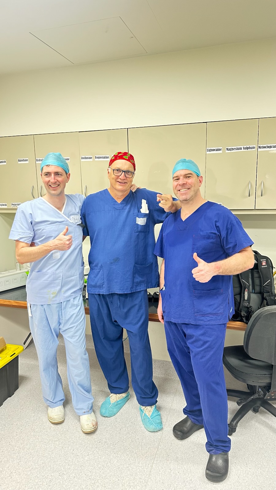 Surgical team in scrubs giving thumbs up
